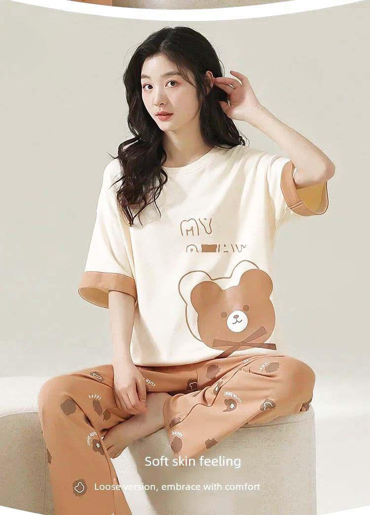 Woman wearing a matching pajama set with a bear design on a neutral background