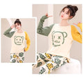 Woman wearing a matching pajama set with a cartoon design on a neutral background