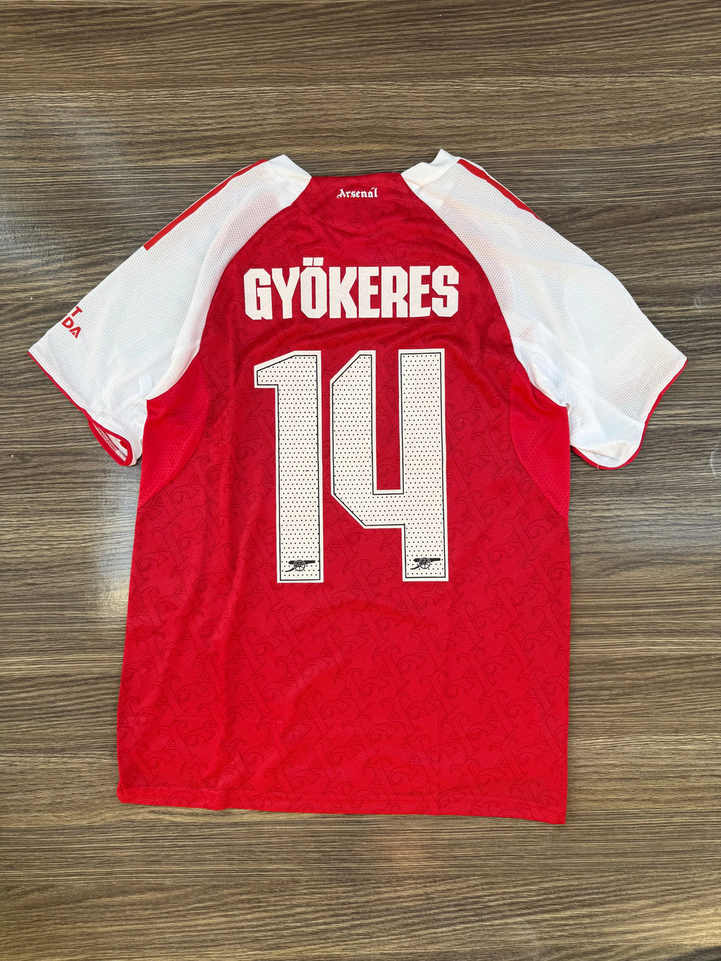 Red sports jersey with 'GYöKERES' and number '14' on a wooden surface