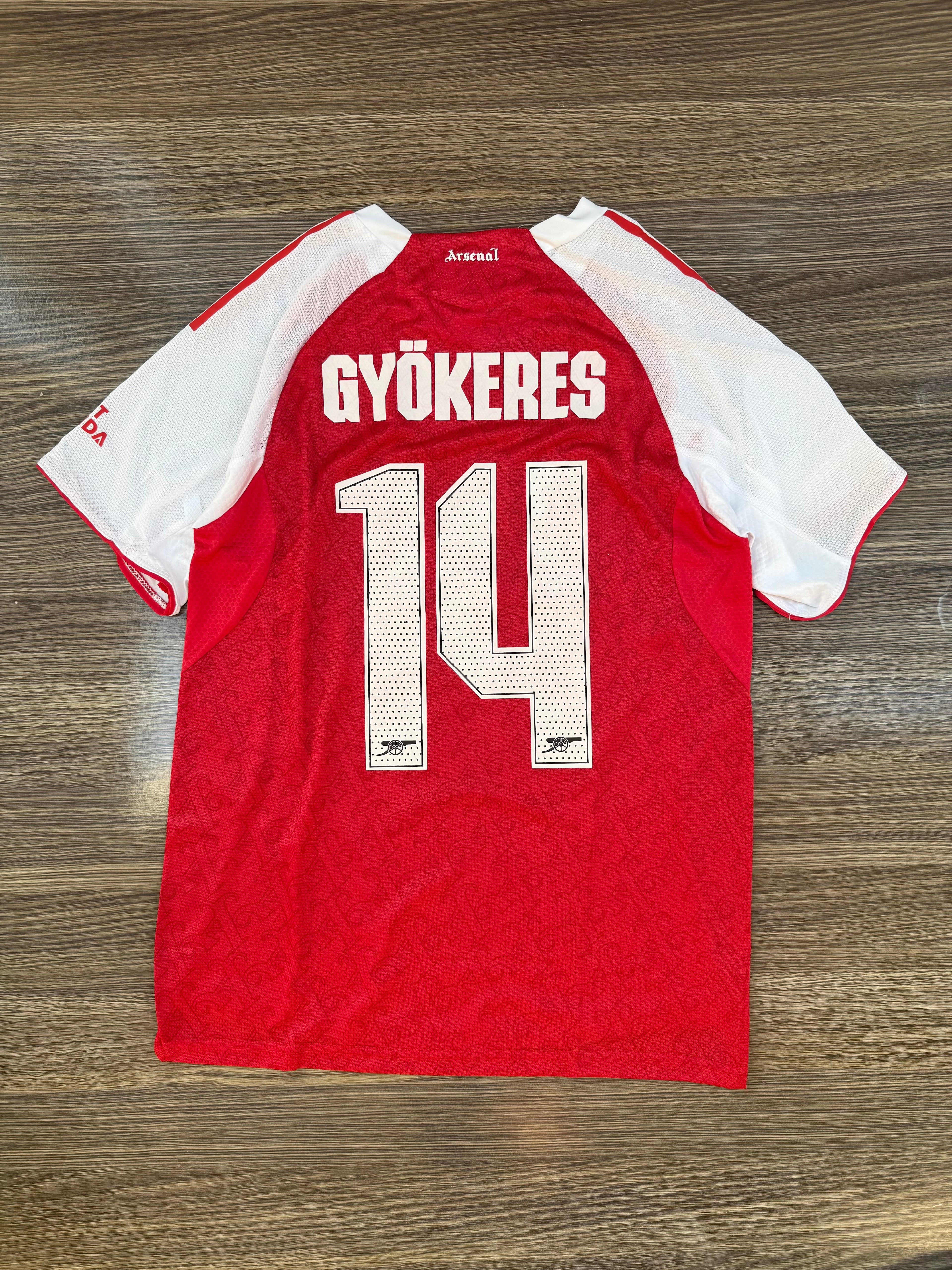Red sports jersey with 'GYöKERES' and number '14' on a wooden surface