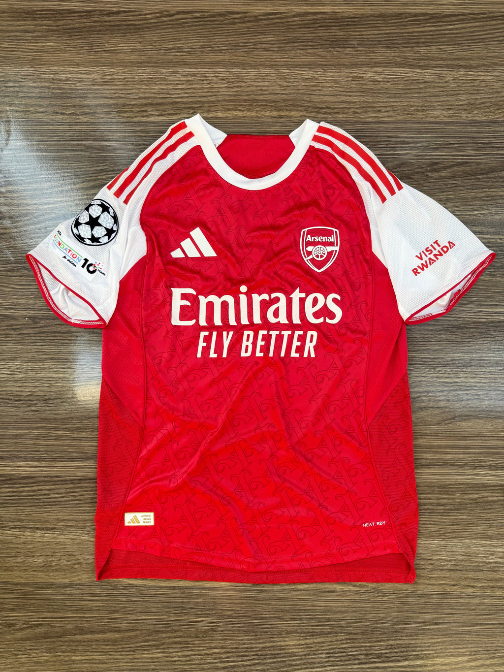 Red sports jersey with white accents on a wooden surface