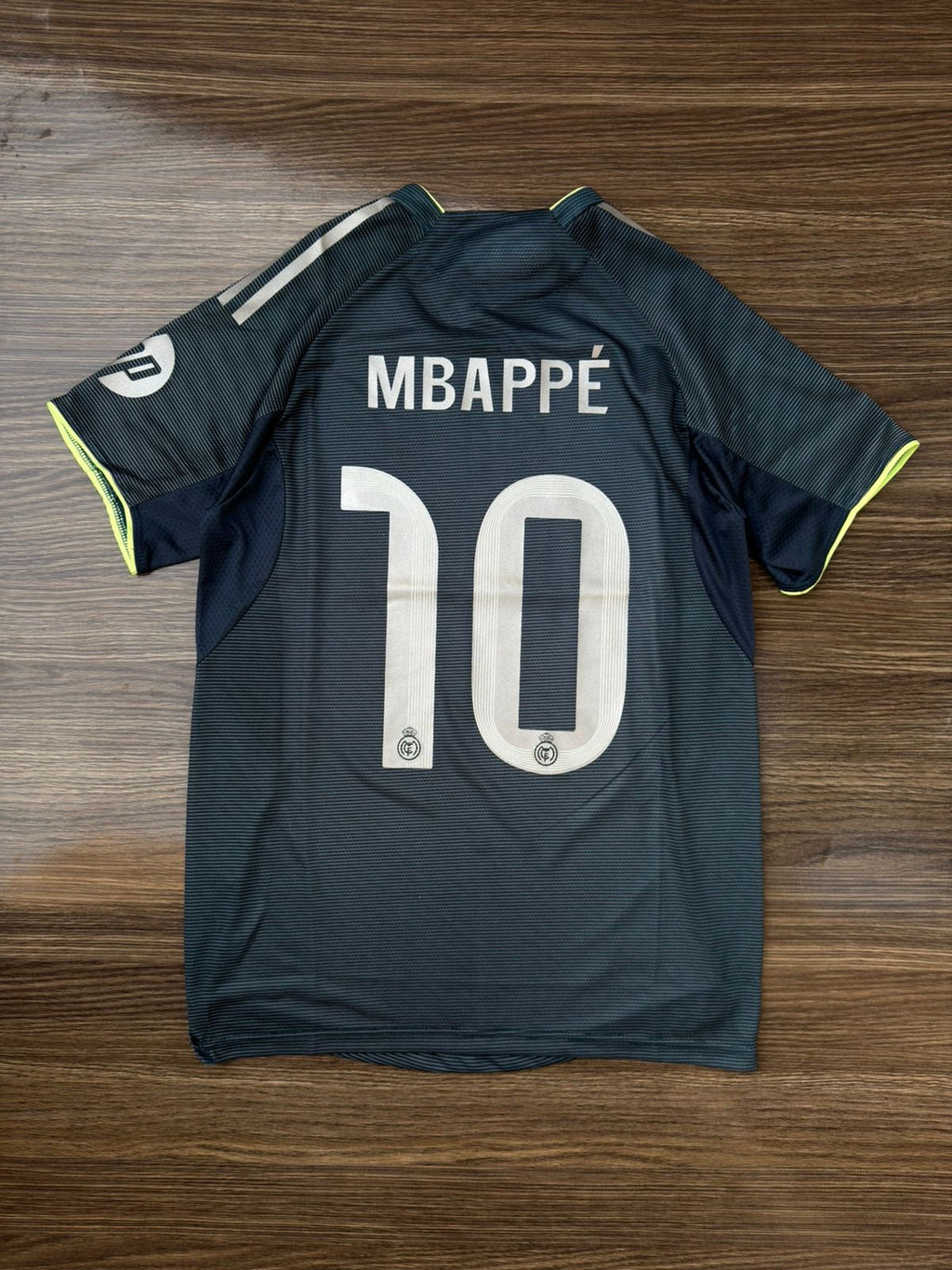 Soccer jersey with 'Mbappé' and number '10' on a wooden surface
