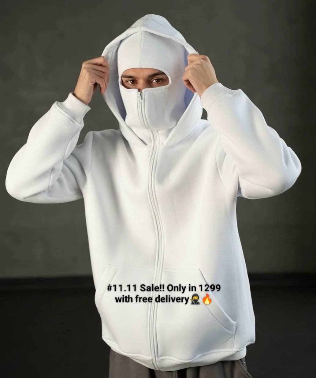 Person wearing a white hoodie with a dark background