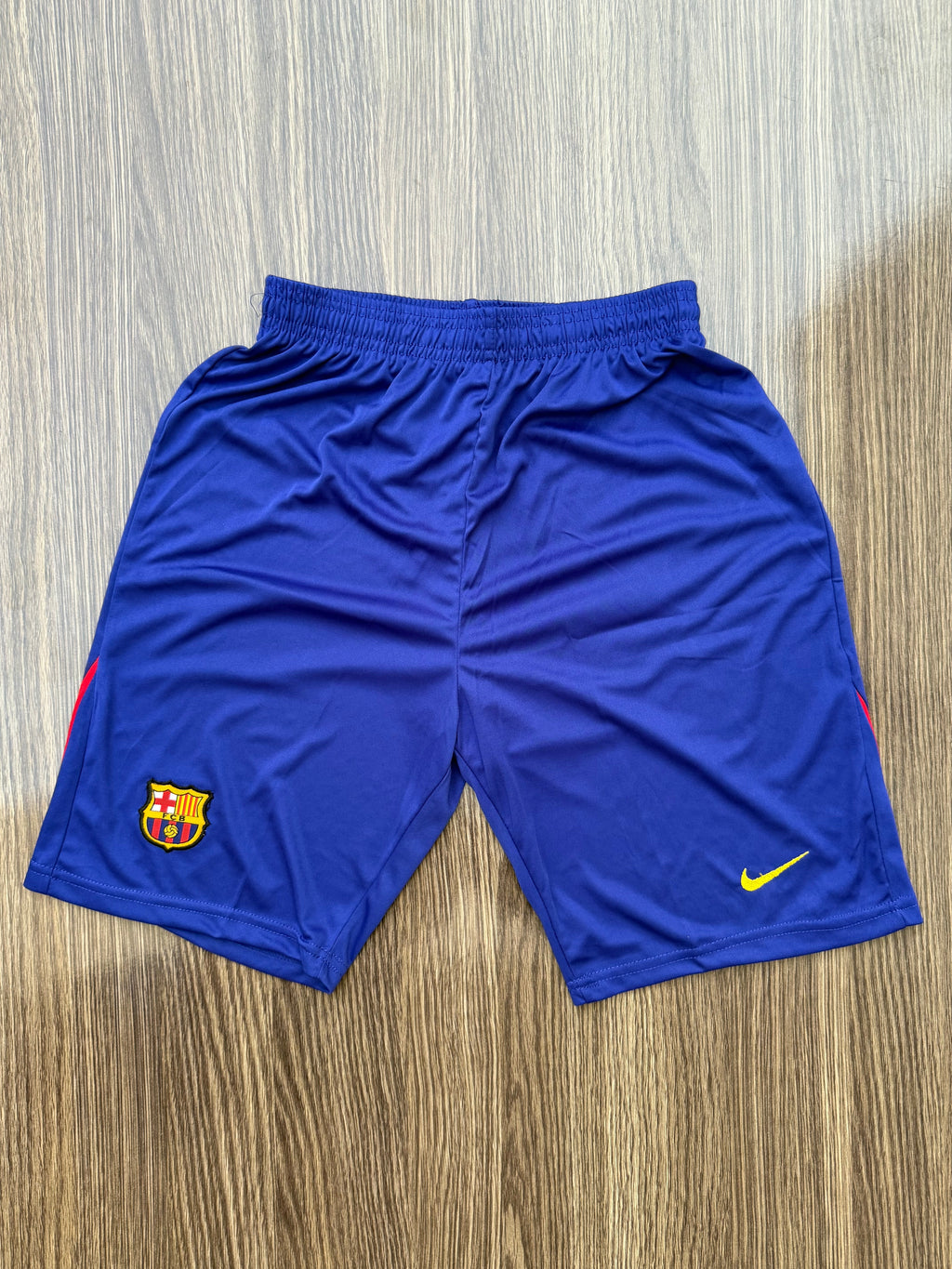 Blue shorts with a logo on a wooden surface