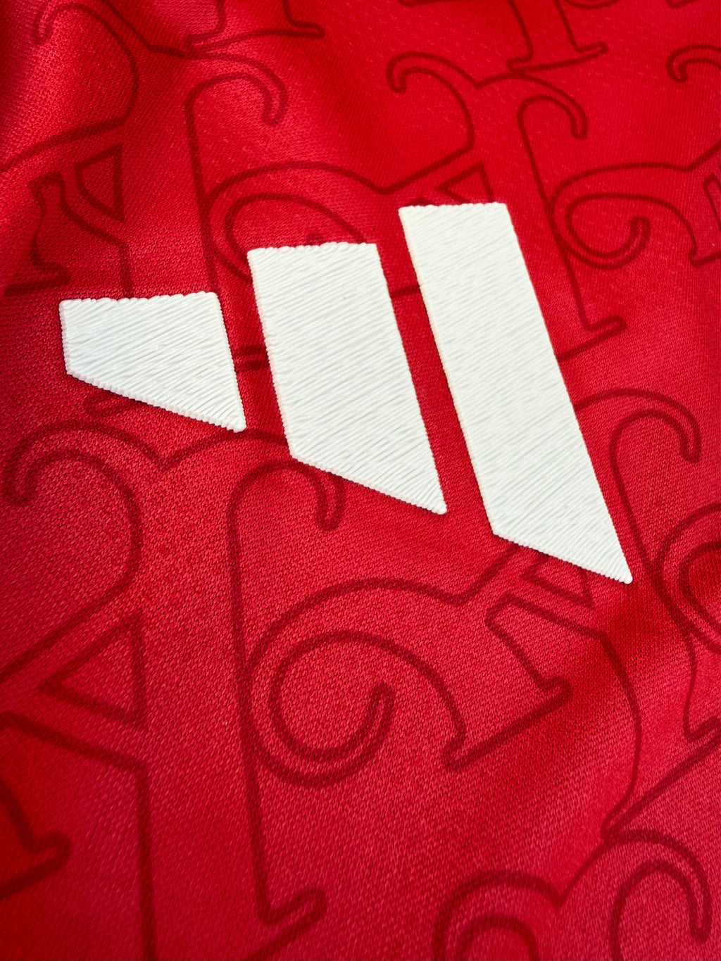 Close-up of a red sports jersey with white number 11 and brand logo.