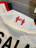 White sports jersey with red logo and text on a textured surface