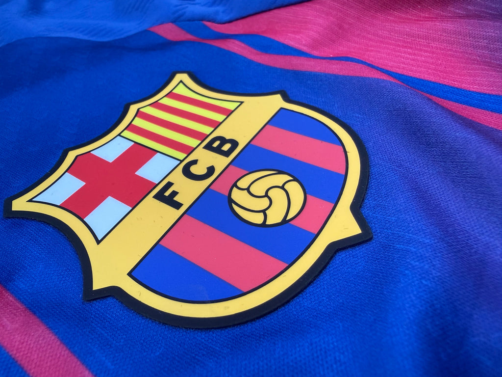 Close-up of FC Barcelona logo on a sports jersey with blue and red stripes.