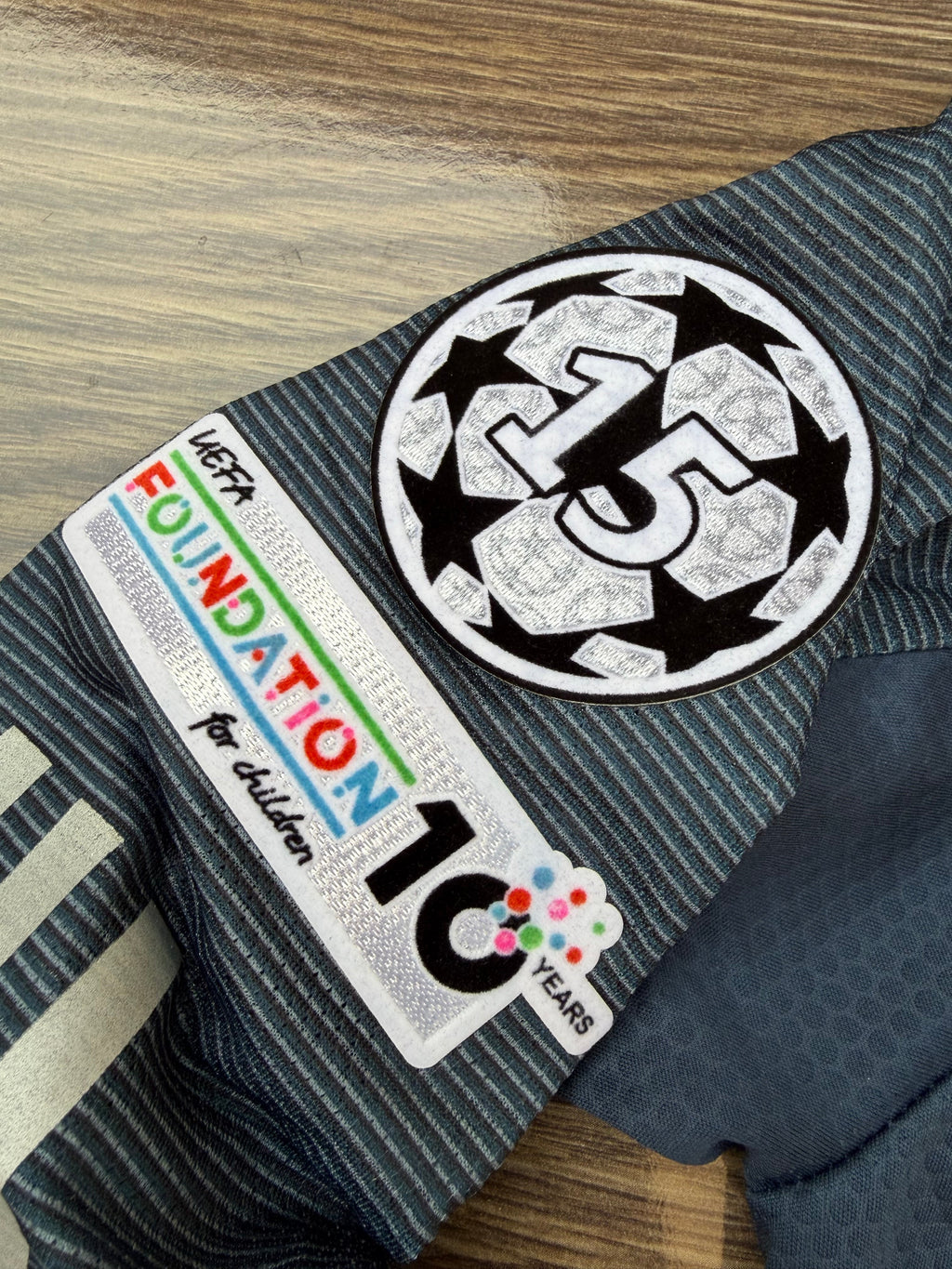 Clothing with a 'Foundation 10' patch on a wooden surface
