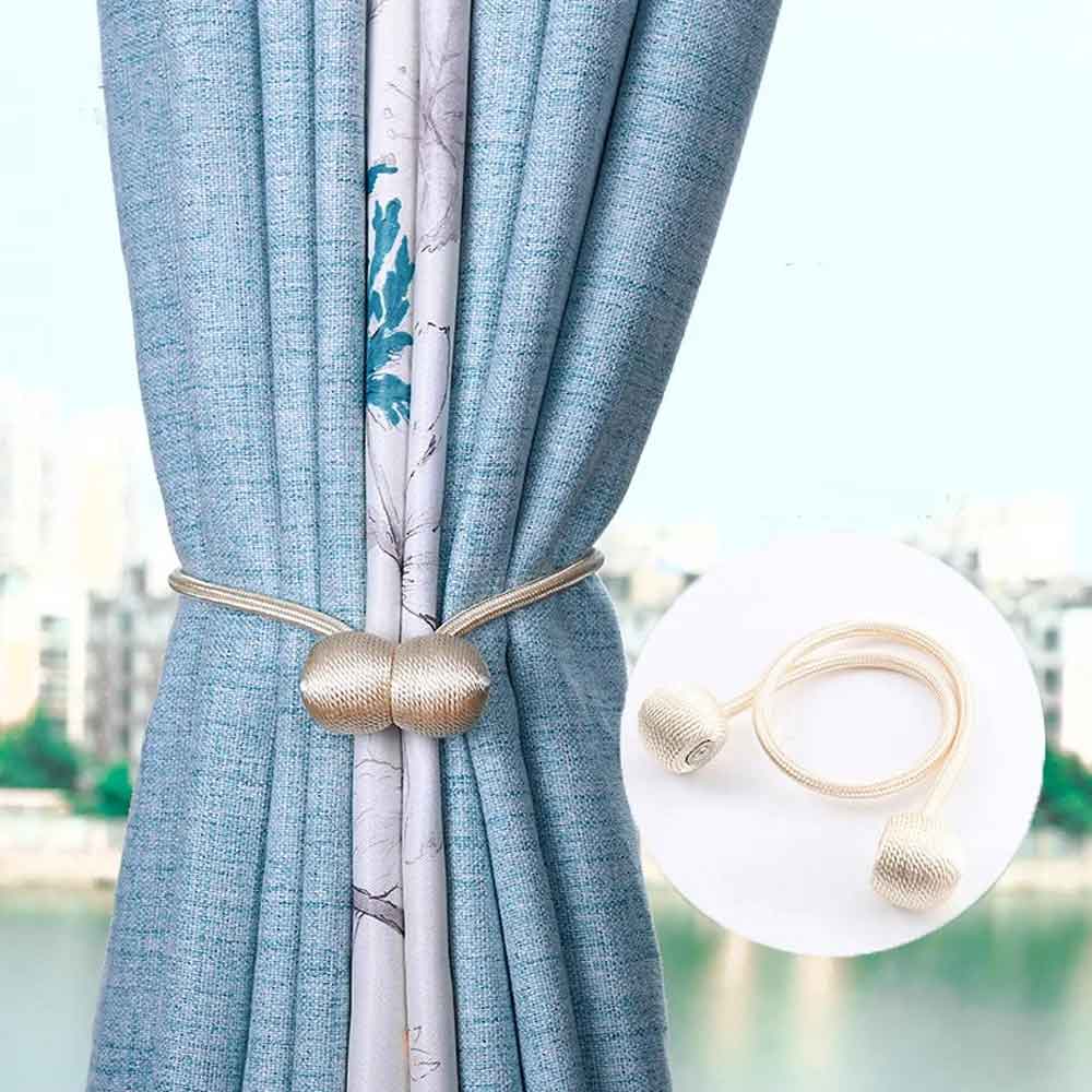 Gold curtain tieback with marble design on a blurred outdoor background