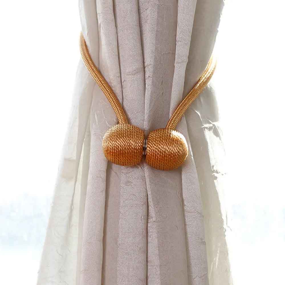 Gold curtain tieback on a white curtain