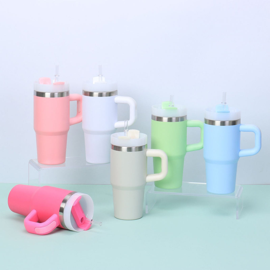Set of colorful insulated travel mugs with handles on a light blue background