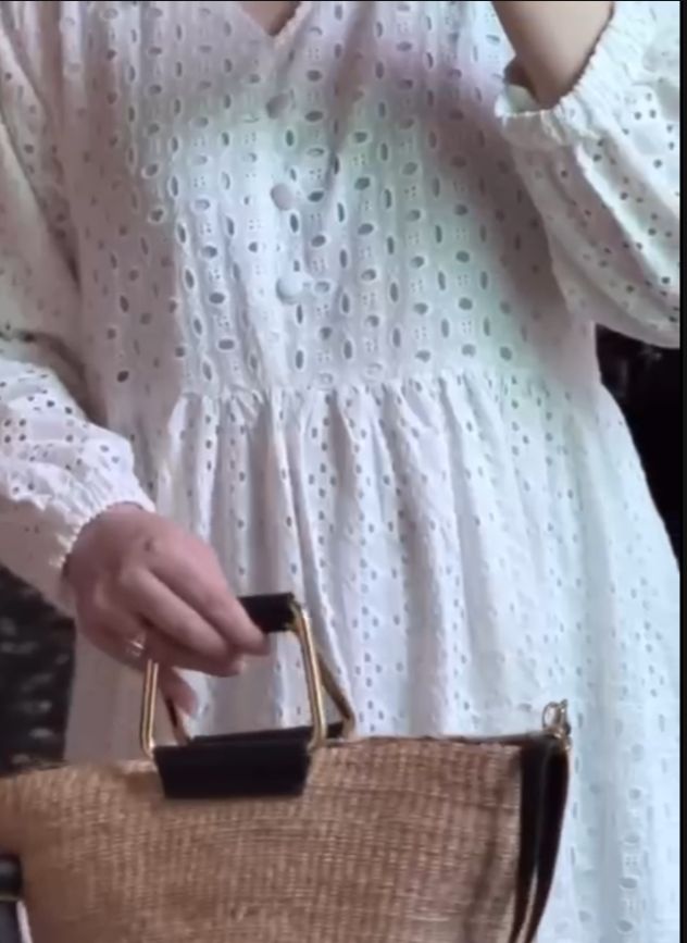 Person wearing a white dress with a black background