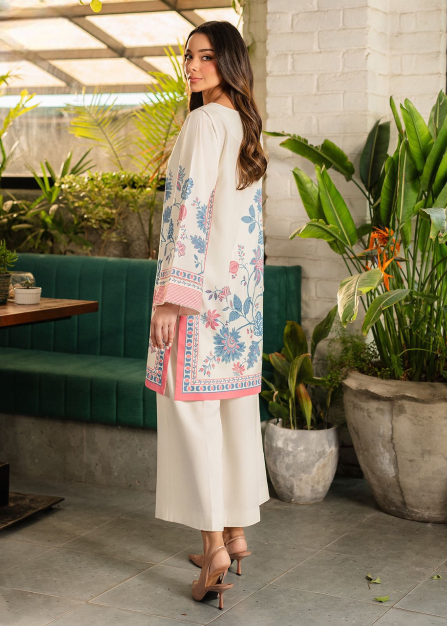 Woman in a floral dress standing in an outdoor setting with plants and a green bench.