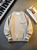 Light gray sweatshirt on a textured surface with a decorative mat in the background
