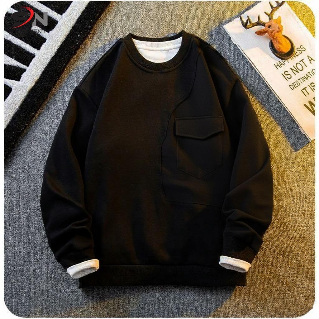 Black sweatshirt with white cuffs on a textured surface