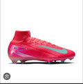Pink soccer cleat with a blue swoosh logo on a white background