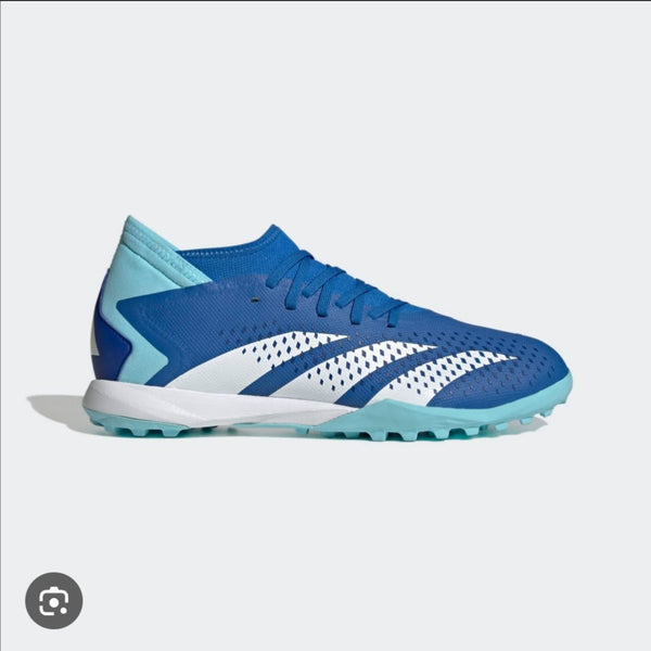 Blue and white sports shoe with cleats on a light gray background