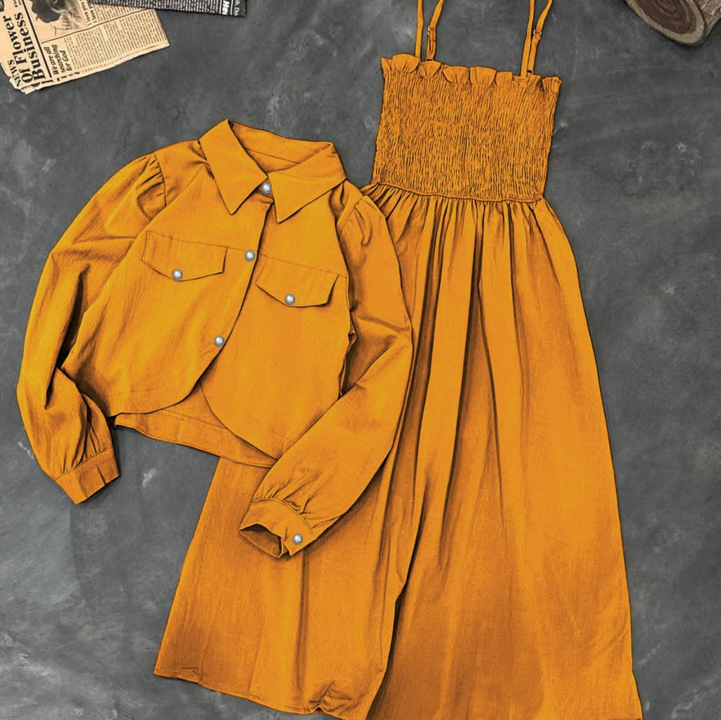 Mustard yellow shirt and dress set on a textured gray surface
