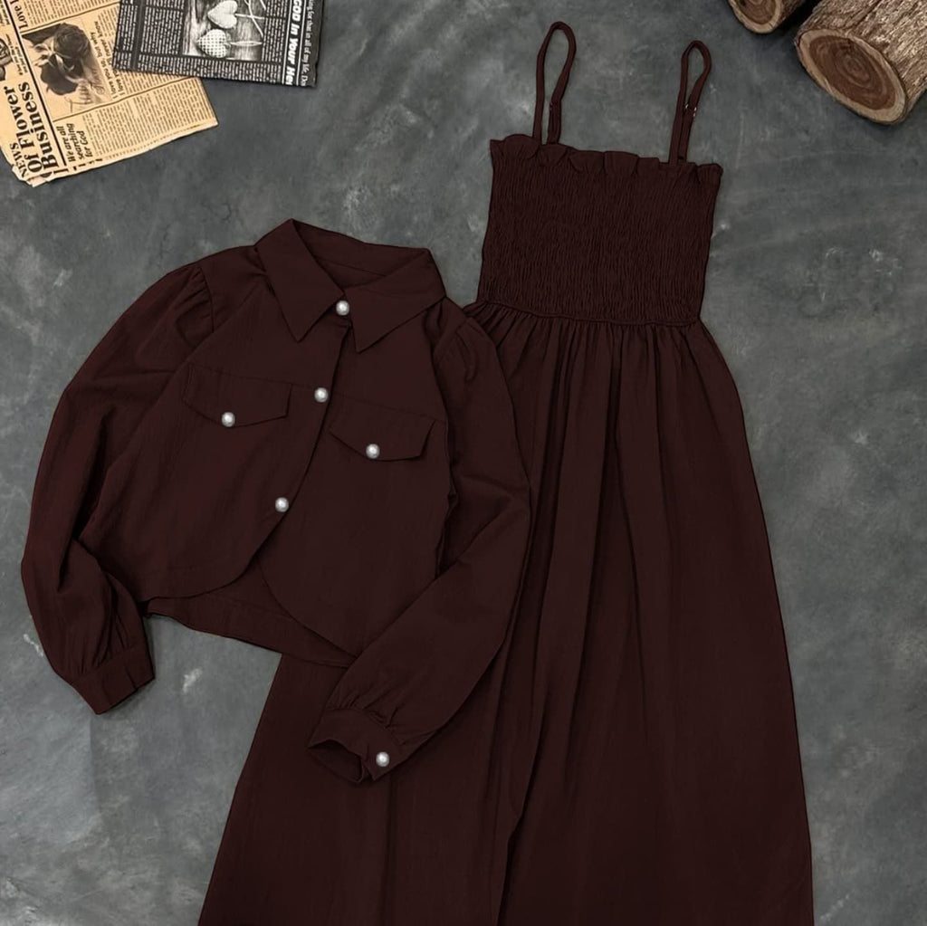 Brown shirt and dress set on a textured gray surface with a newspaper and logs in the background.
