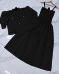 Black dress with buttons on a white tiled floor