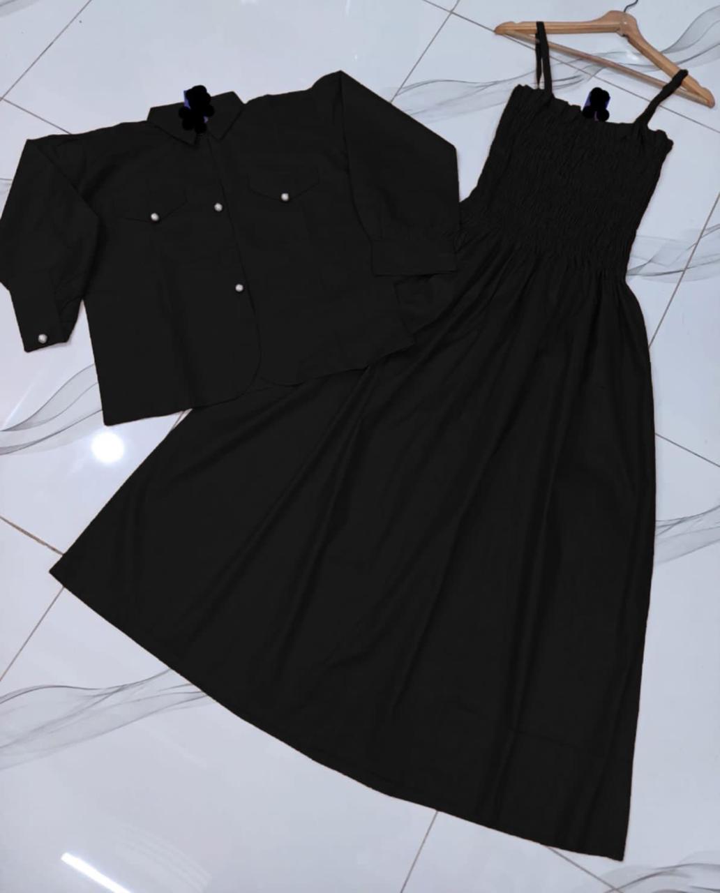 Black dress with buttons on a white tiled floor