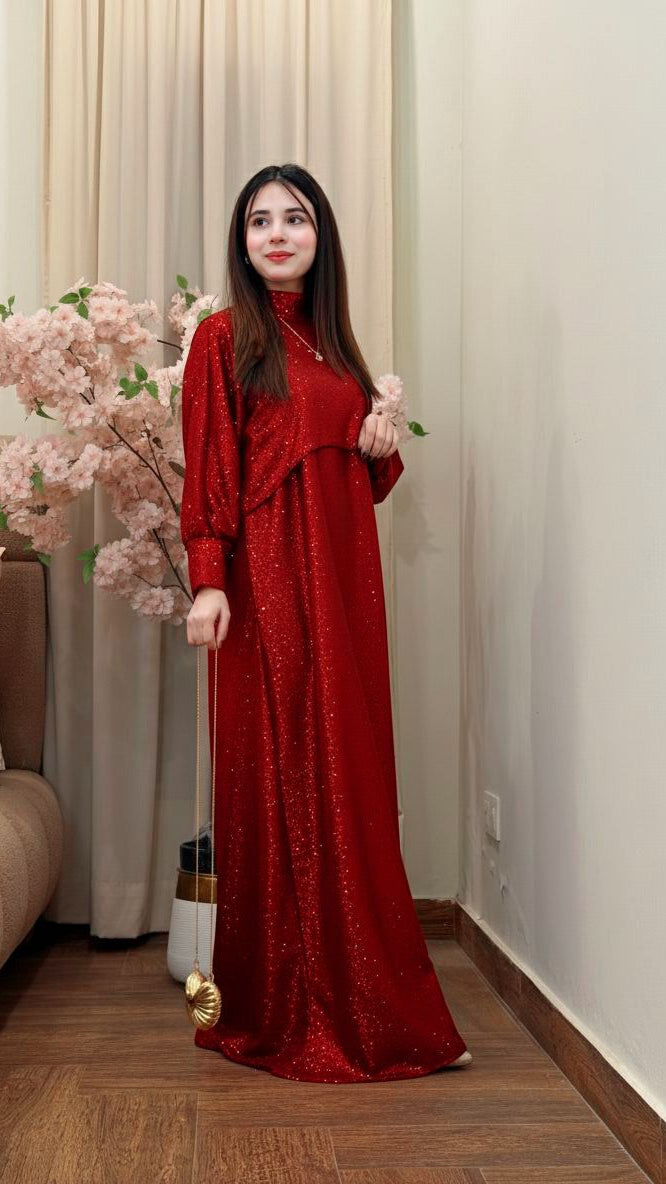 Woman in a red dress holding flowers indoors with a neutral background