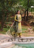 Woman in a yellow and green traditional outfit standing outdoors with 'Nina' branding.