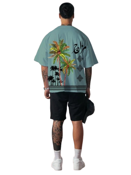 Person wearing a light blue t-shirt with tropical designs on a white background