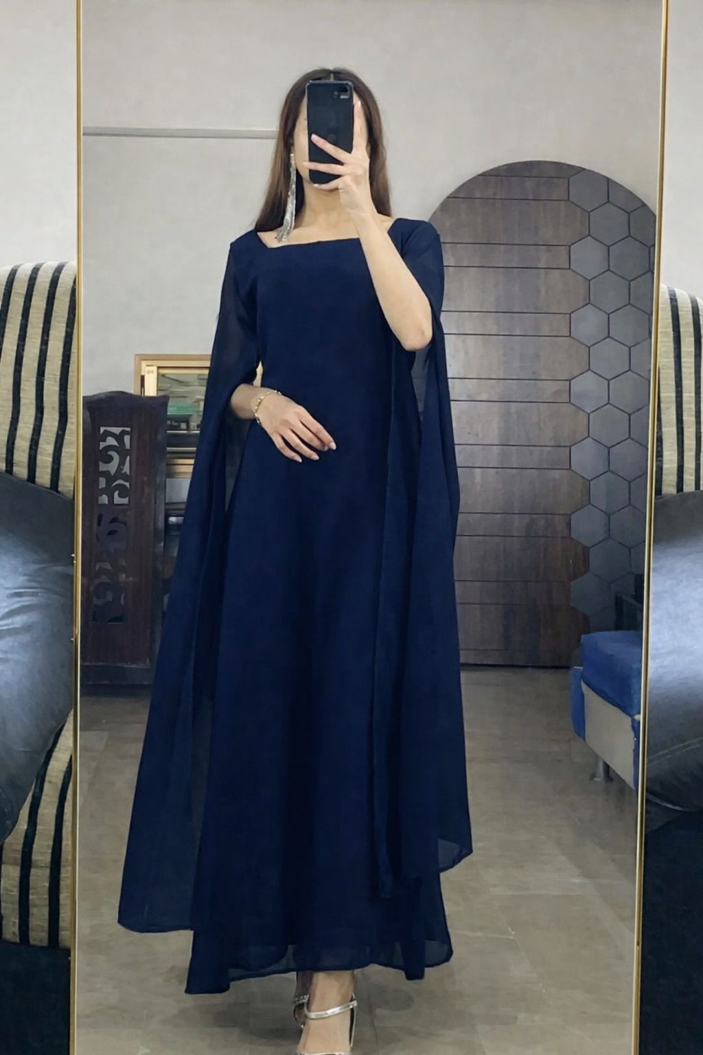 Person wearing a navy blue dress taking a mirror selfie.