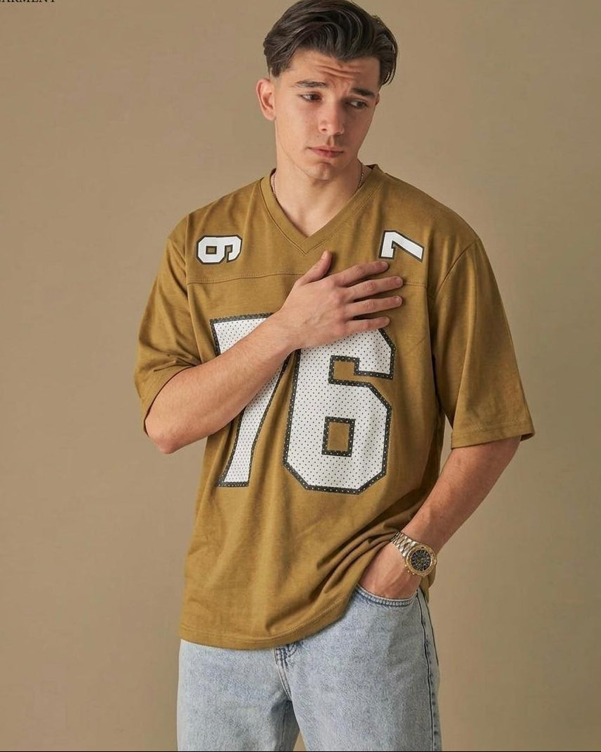 Man wearing a mustard yellow sports jersey with number 76 on a beige background
