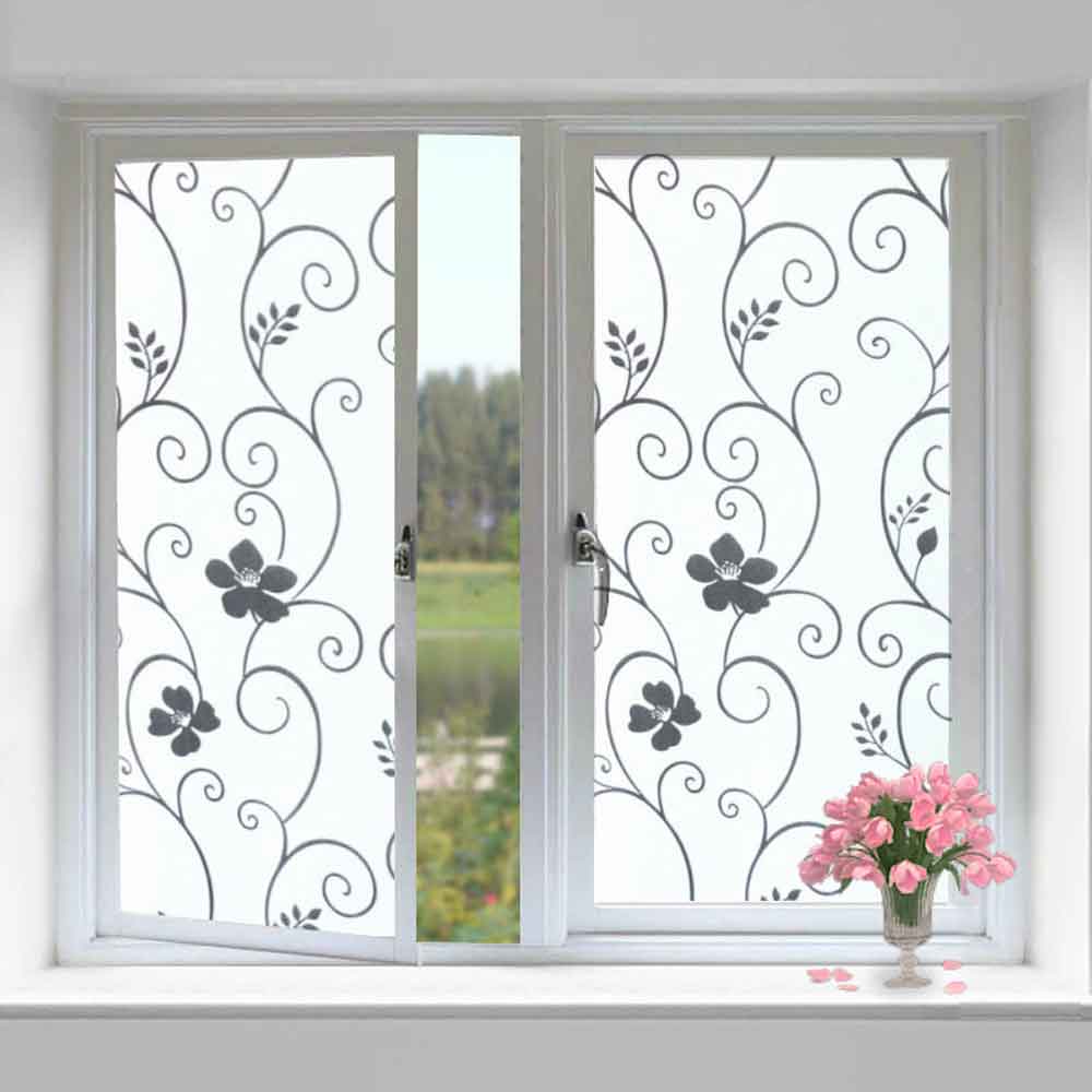 Decorative window film with floral patterns on a glass door with a vase of pink flowers on a table.