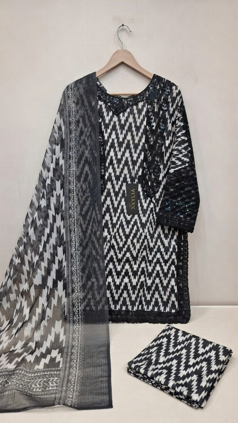 Black and white patterned dress with matching dupatta on a hanger against a white background