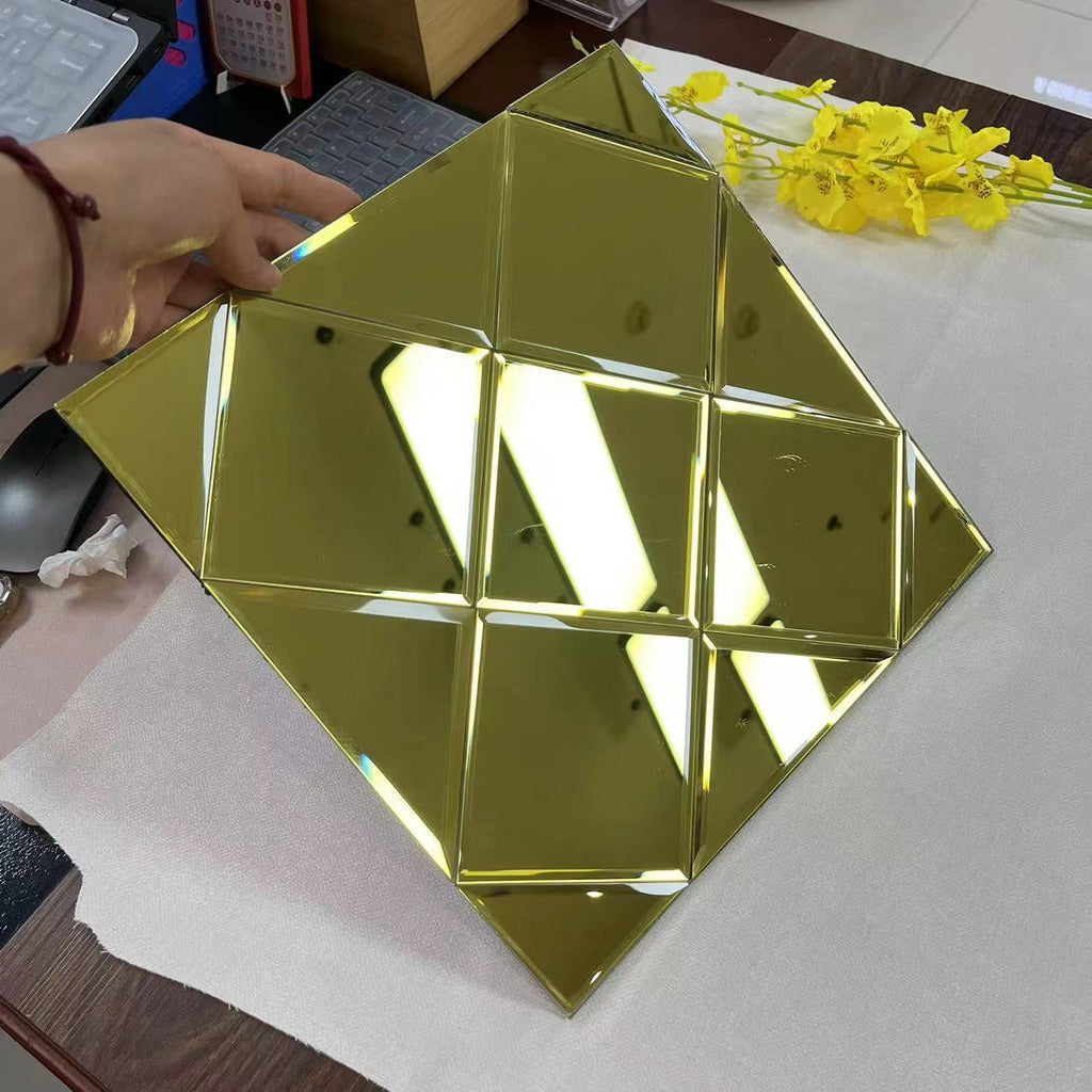 Gold geometric mirror on a table with a hand and flowers in the background