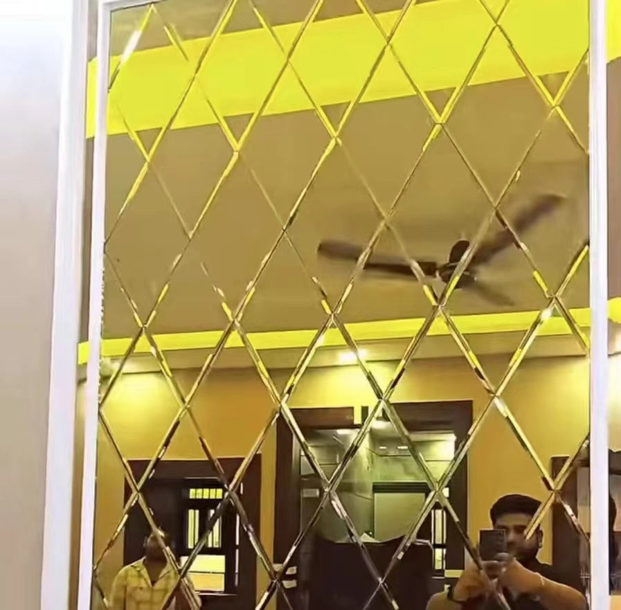 Decorative wall with geometric pattern in a room with people and a ceiling fan.