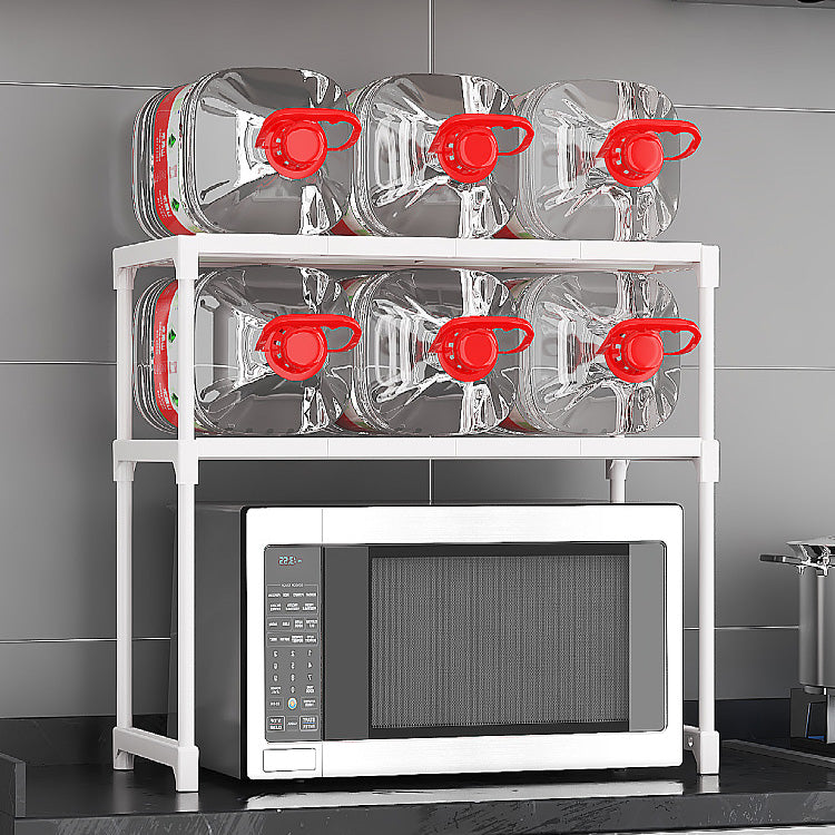 Stack of clear containers with red lids on a white rack above a microwave.