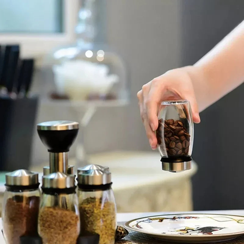Hand using a pepper grinder with a blurred kitchen background