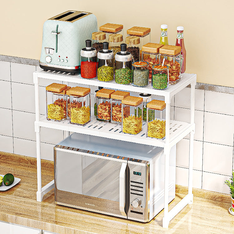 Kitchen setup with a microwave on a stand and various jars of food.