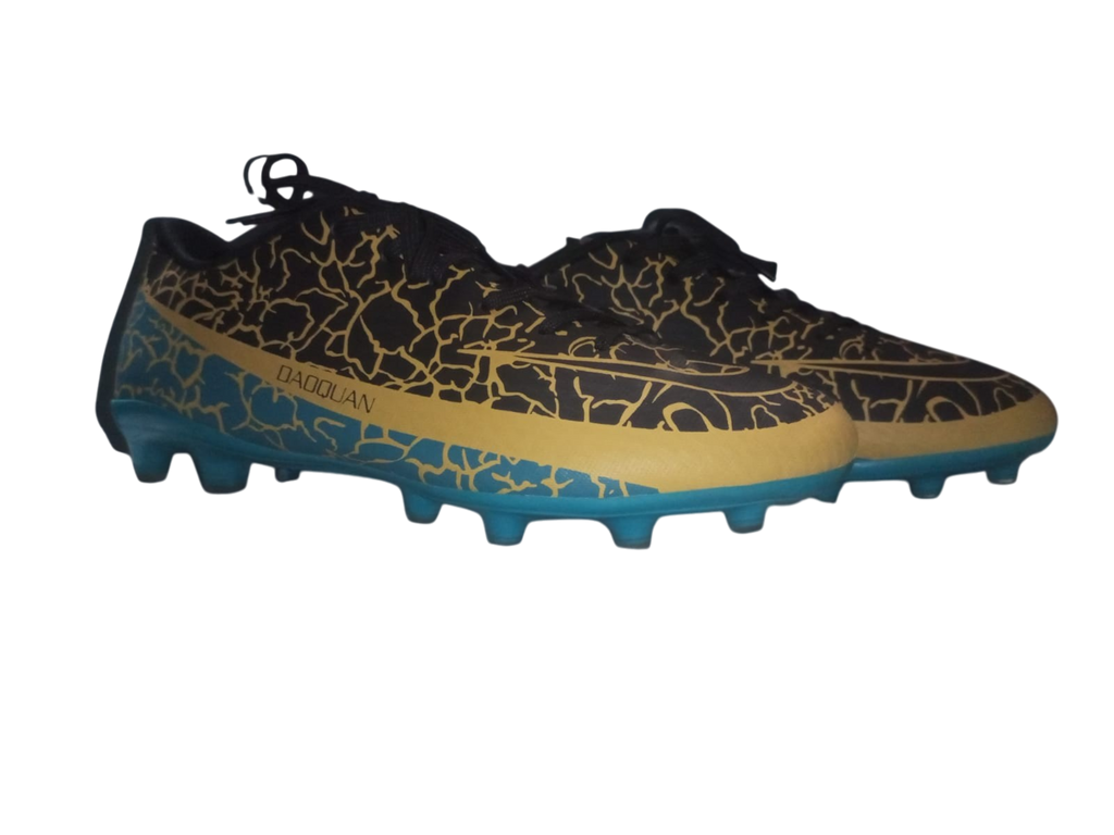Pair of black and gold soccer cleats with blue soles on a white background