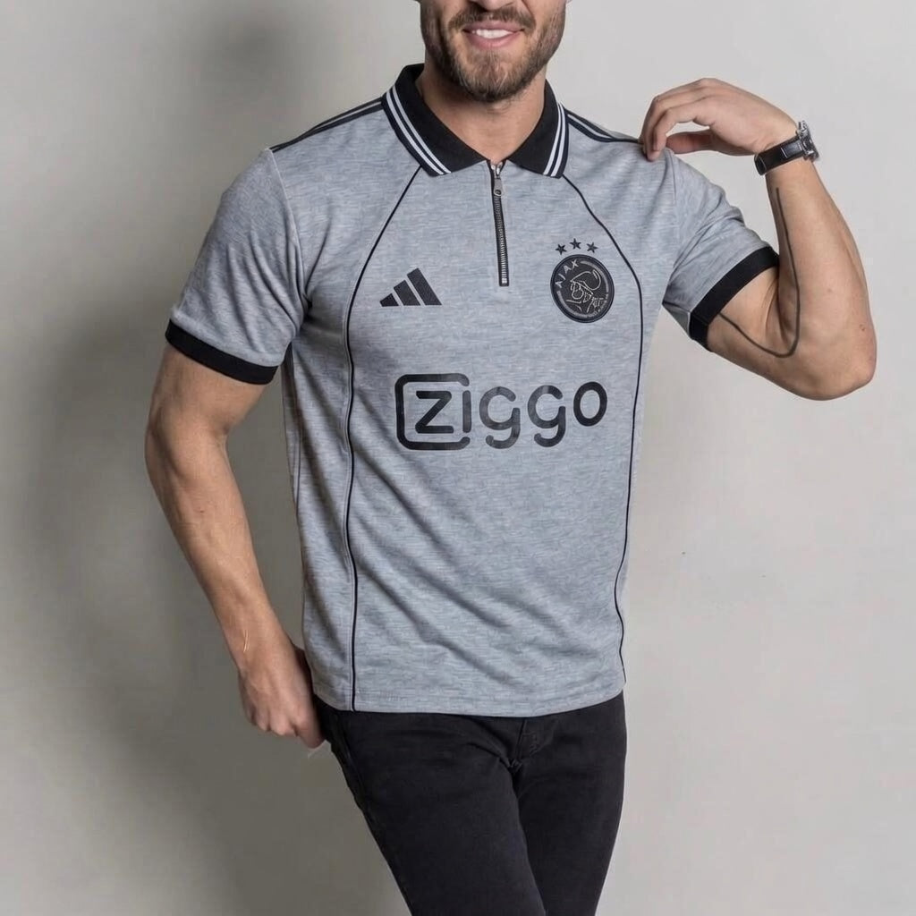 Man wearing a gray sports jersey with Adidas and Ziggo logos on a plain background